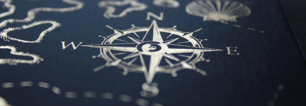 A close up of a compass on a table, midhaven, astrology, zodiac, career, entrepreneur
