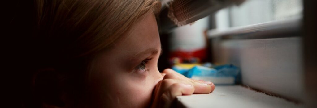 girl in blue shirt looking at the window